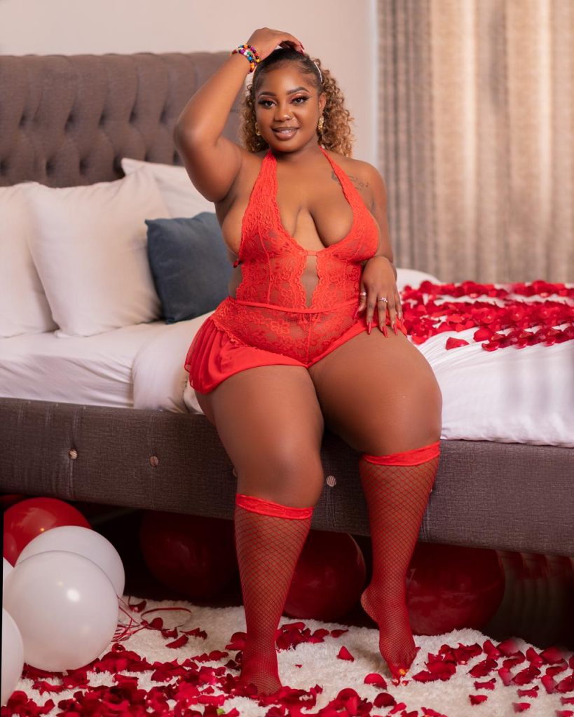Plus-size model in a red bodysuit Lingerie seated on a bed with roses ready to Demystifying Body Standards in Nairobi's Lingerie World